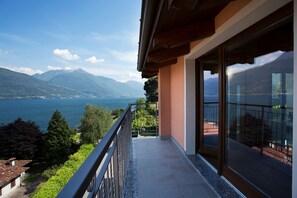 A balcony with a view of a lake and mountains. - Casa Attico Al Porto (Pianello del Lario)