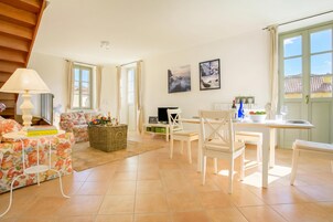 Amplia sala de estar con sofá, mesa de comedor y televisor.