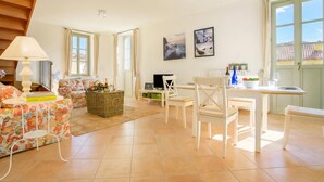 A spacious living area with a sofa, a dining table, and a TV.