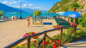 A beachside area with lounge chairs, umbrellas, and a dining table.