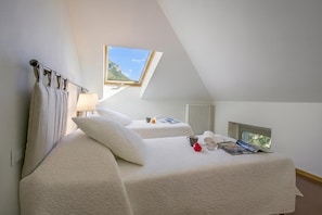 A bedroom with two beds, a skylight, a radiator, and a window with a mountain view. - Casa Al Prato Apt. F (Varenna)