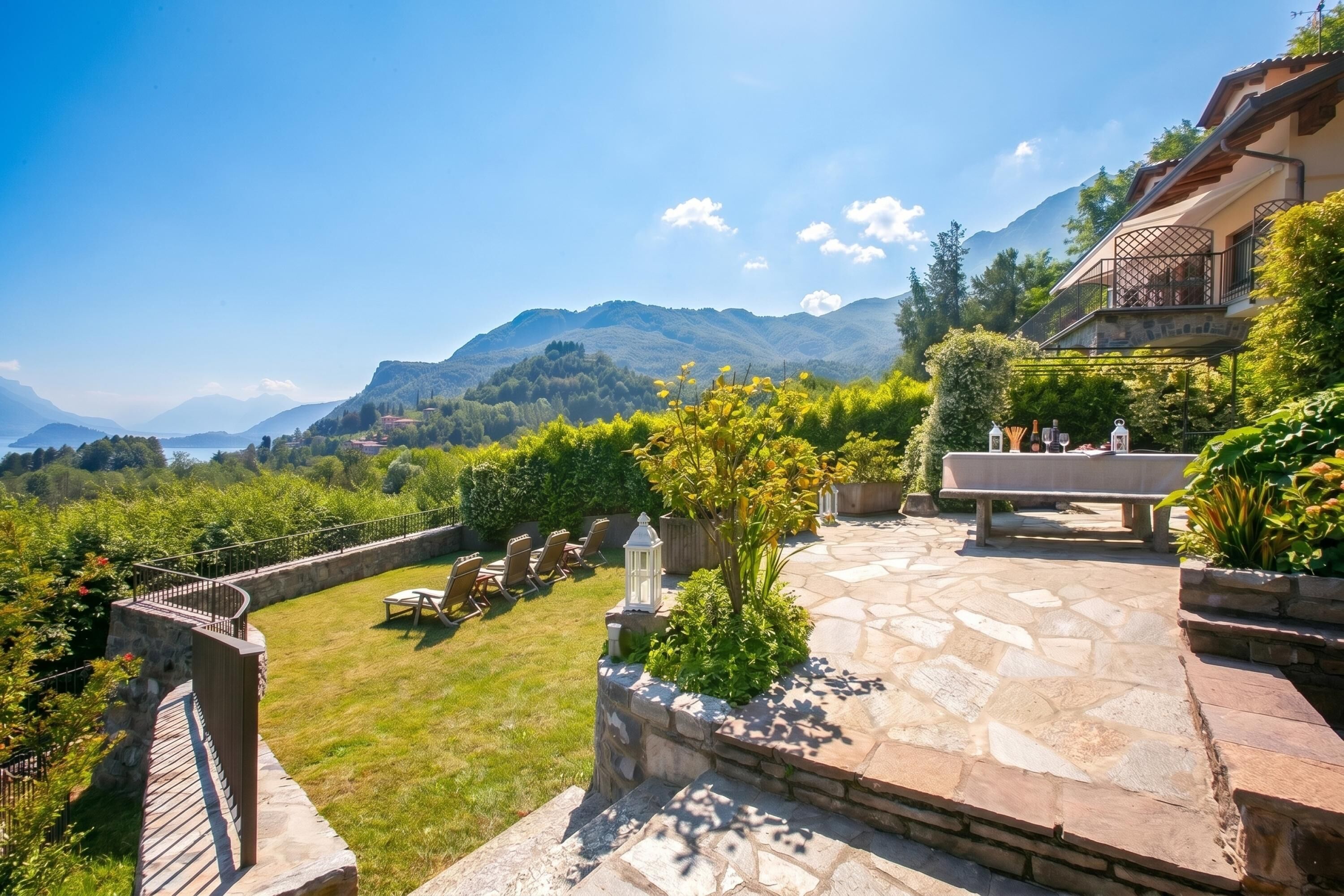A stone patio with outdoor furniture, a stone wall, and a view of mountains.