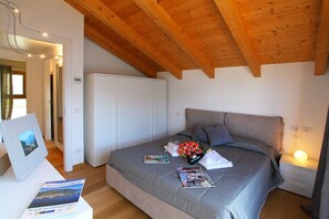 Une chambre à coucher avec un lit, une table de chevet avec une lampe, une armoire et un tableau encadré au mur.