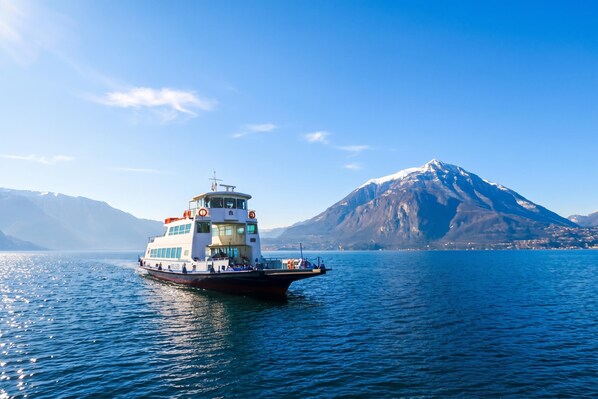 A boat on calm water with a mountain in the background. - Riva Bellano Margherita 2 (Bellano)
