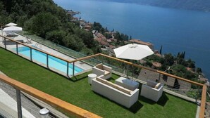 Zona de piscina con vista a un lago y montañas.