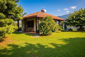 A house with a tiled roof, a satellite dish, and a well-maintained lawn. - Villa Il Castagno (Cerano d'Intelvi)