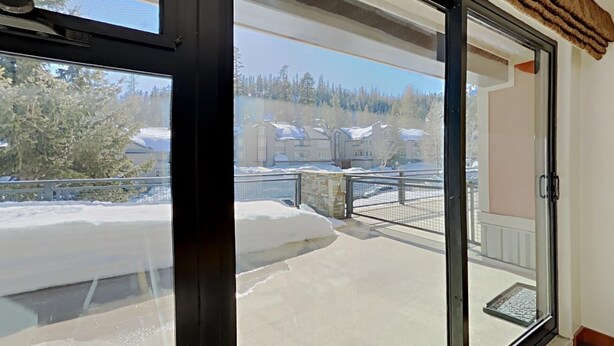 A balcony with a view of a snowy landscape and buildings. - Renovated Condo Across the Street from Mountain Biking Trails! by RedAwning (Mammoth Lakes)