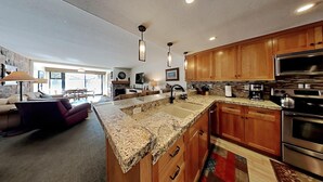 A modern kitchen with granite countertops, wooden cabinets, and stainless steel appliances. - Renovated Condo Across the Street from Mountain Biking Trails! by RedAwning (Mammoth Lakes)