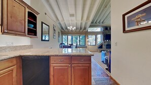 A kitchen with wooden cabinets, a granite countertop, and a built-in dishwasher. - Family Friendly Spacious Mountain 4 Bedroom Condo - Closest to Canyon Lodge! by RedAwning (Mammoth Lakes)