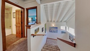 A staircase with a wooden handrail, a sign indicating a ski area boundary, and a bed with a nightstand in the background. - Family Friendly Spacious Mountain 4 Bedroom Condo - Closest to Canyon Lodge! by RedAwning (Mammoth Lakes)