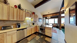 A spacious kitchen with wooden cabinets, a built-in oven, and a large window providing natural light.
