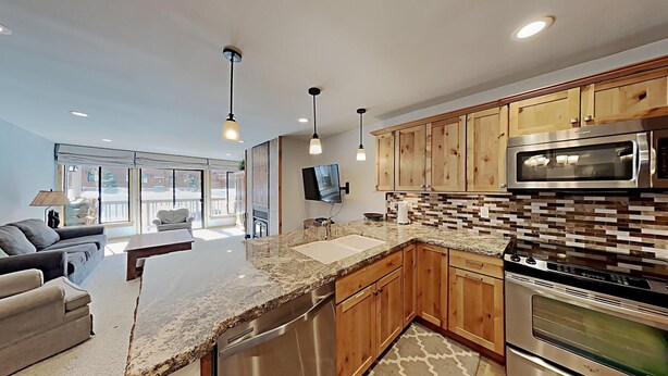 A modern kitchen with wooden cabinets, stainless steel appliances, and a large island. - Stay mountainside! One Bedroom Condo Just Steps to the Mountain and 1 Mile to the Village at Mammoth by RedAwning (Mammoth Lakes)