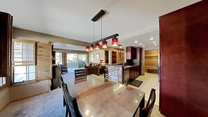 Una cocina amplia con una isla central, muebles de madera e iluminación colgante.