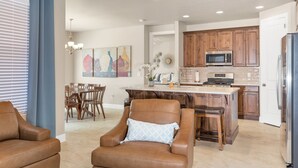 A modern kitchen with wooden cabinets, a stainless steel refrigerator, and a built-in microwave.