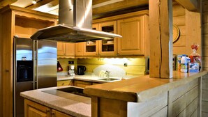 Eine Küche mit Holzschränken, Edelstahlgeräten und einer Arbeitsplatte aus Granit.