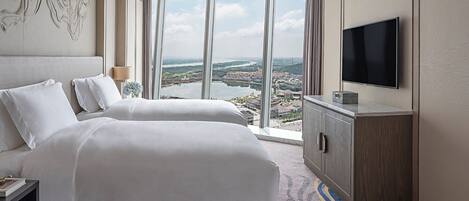 Habitación de hotel con una cama grande, un televisor y vistas a la ciudad.