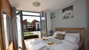Ein Schlafzimmer mit Bett, einem Esstisch mit Frühstück, einem Fenster und Blick nach draußen.