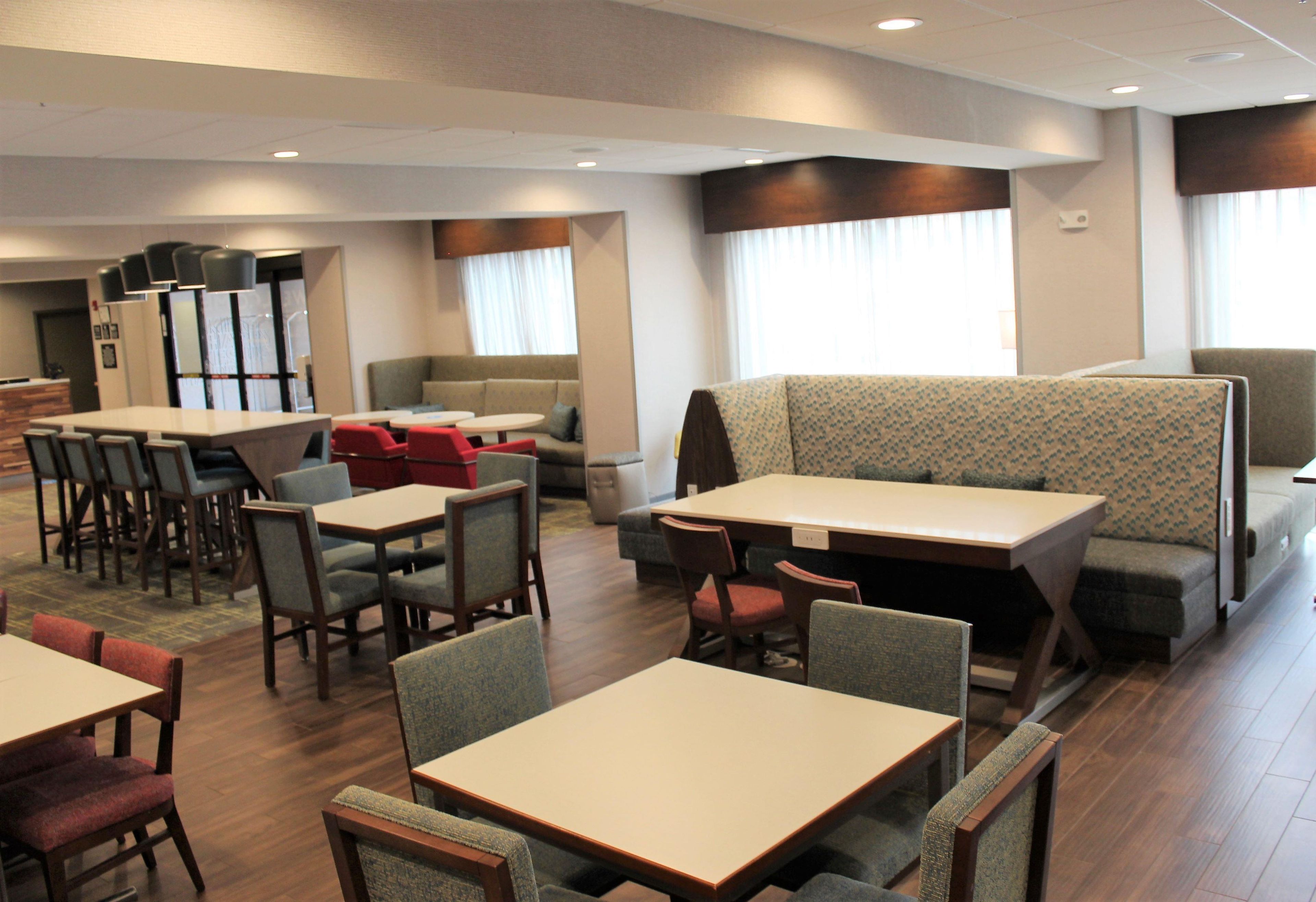 Comedor de hotel con diversas opciones de asientos, incluyendo cabinas, mesas y sillas.
