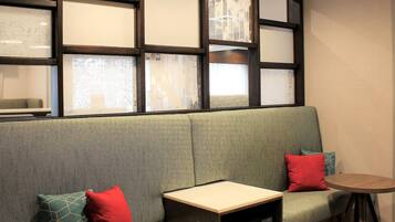 A seating area with a sofa, a small table, and a printer.