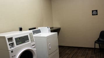 Une buanderie avec un comptoir d’accueil, un lave-linge et un sèche-linge.