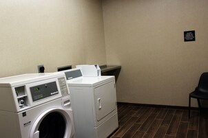 A laundry room with a front desk sign, a washing machine, and a dryer.