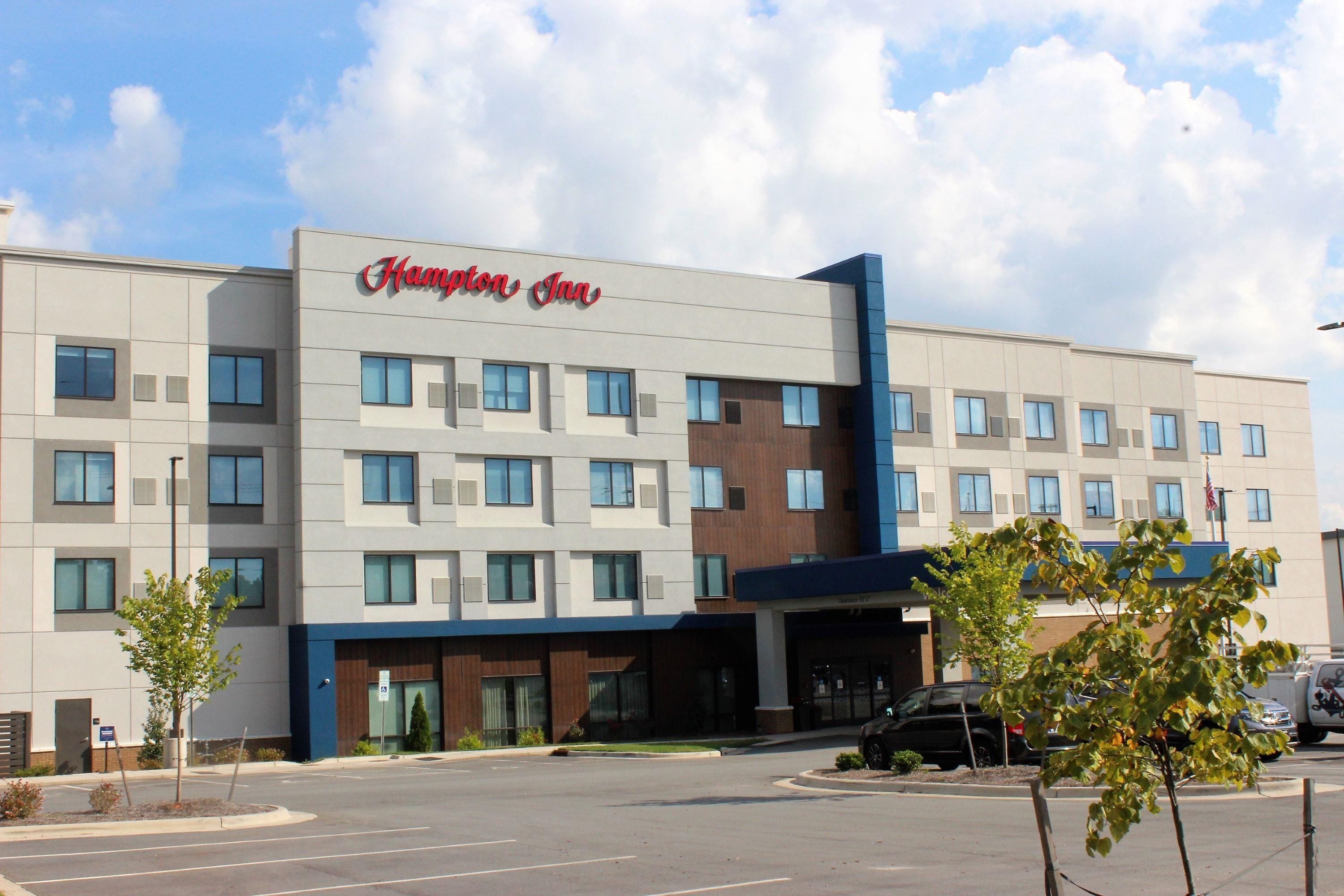 Modernilla julkisivulla, useilla ikkunoilla ja omalla pysäköintialueella varustettu Hampton Inn -hotelli.