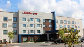 Modernilla julkisivulla, useilla ikkunoilla ja omalla pysäköintialueella varustettu Hampton Inn -hotelli.