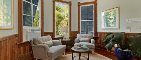 A living room with two sofas, a coffee table, and a large potted plant.