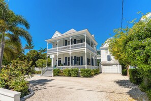 A two-story white house with a balcony, a garage, and a gravel driveway. - CAPTIVA ~  Adults Only,  King Room with Community Pool at Azul Mansion! (Key West)