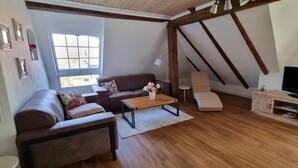 Una sala de estar con sofá, mesa de centro y mueble para televisión.