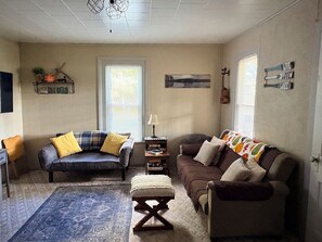 A cozy living room with two sofas, a coffee table, and a rug.