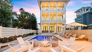 A multi-story building with a pool, outdoor seating, and a fire pit. - Spacious Porch with Pool and Firepit (Panama City Beach)