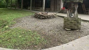 A rustic wooden building with a balcony, a stone well, and a treehouse. - Enjoy the River Breeze (Tompkinsville)