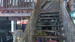 A rustic wooden staircase with a vintage sign above it. - Enjoy the River Breeze (Tompkinsville)