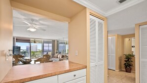 A hotel room with a balcony, a ceiling fan, a dining area, and a view of the cityscape. - Vanderbilt Towers - Walk to the Beach! (Naples)