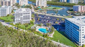 A high-rise hotel with a rooftop pool, a marina with boats, and a parking lot. - Vanderbilt Towers - Walk to the Beach! (Naples)
