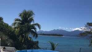 A swimming pool with a view of a mountain range and a body of water. - LE FLAMBOYANT, triplex sea view, 3 bedrooms, residence with swimming pool (le Gosier)