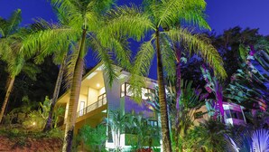 A multi-story building with balconies, surrounded by lush tropical vegetation. - Macaws and Sloths and Monkeys, Oh My! Villa Capuchin in Manuel Antonio (Manuel Antonio)