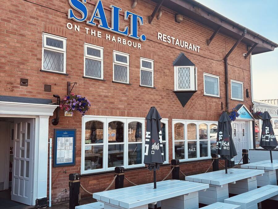 Un edificio in mattoni con un'insegna che riporta la scritta 'SALT ON THE HARBOUR RESTAURANT'.