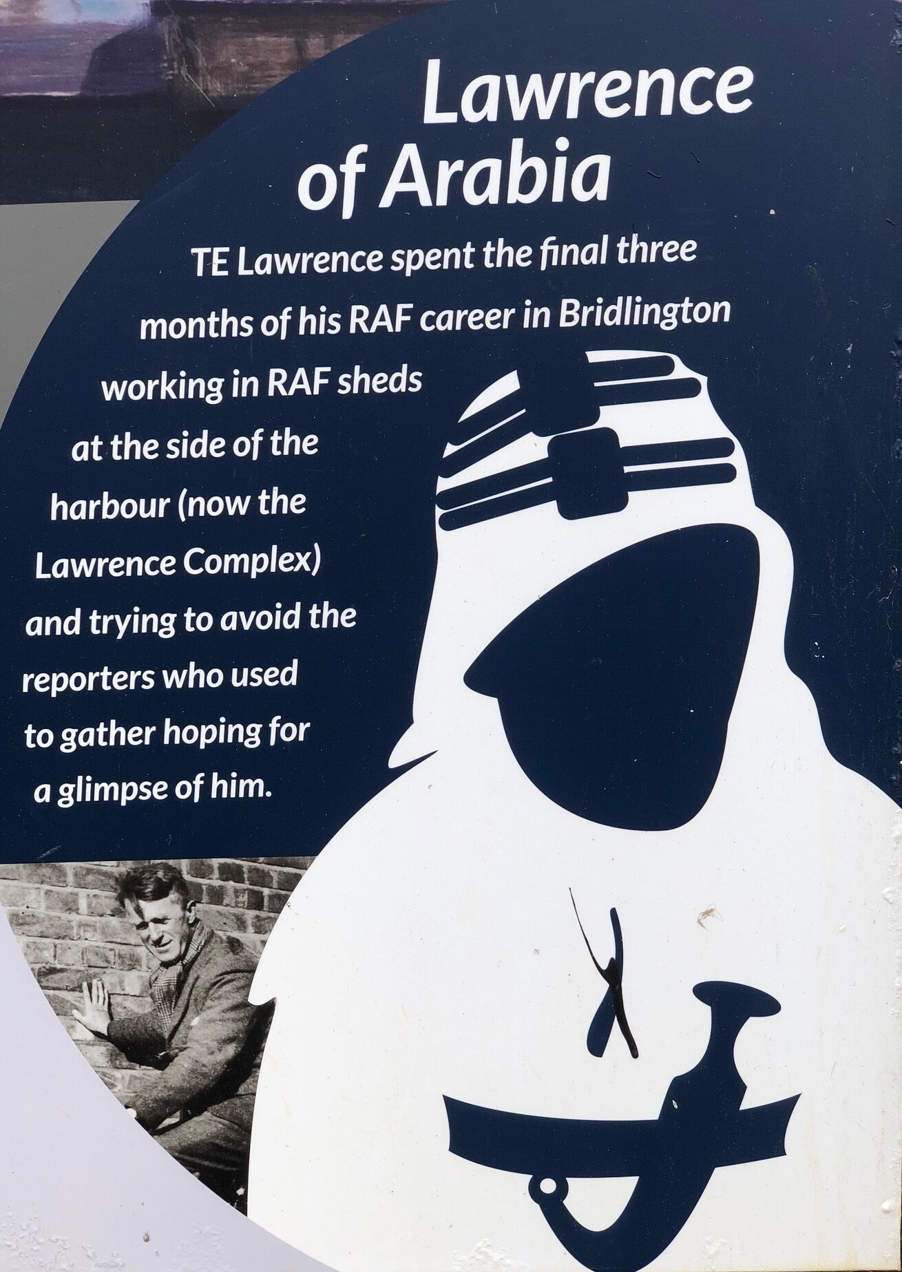 A poster with a silhouette of a person wearing a military helmet and a scarf, with text describing TE Lawrence's RAF career in Bridlington.