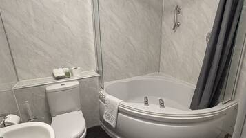 Un baño con inodoro, lavamanos y cabina de ducha con puerta de cristal.
