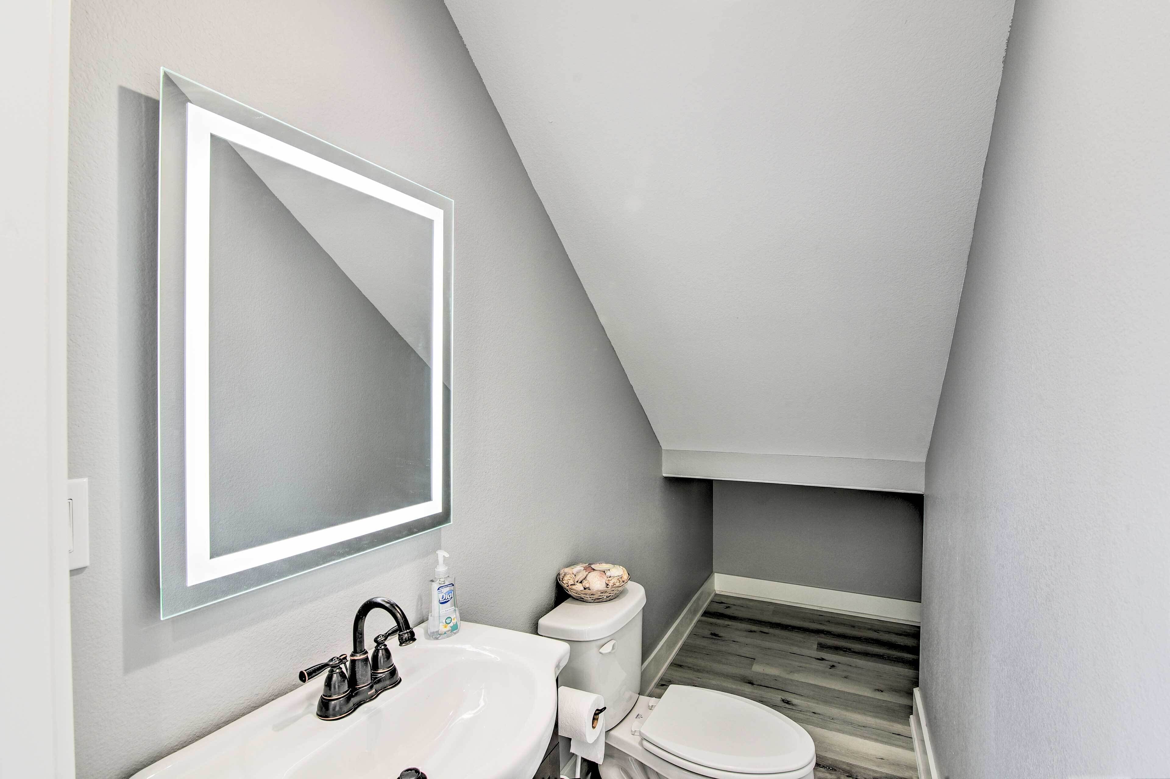 Une petite salle de bain moderne avec un lavabo blanc, un miroir et des toilettes.