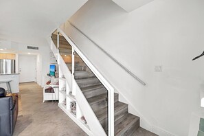 Un intérieur moderne comprenant un escalier, un coin cuisine et un espace salon.