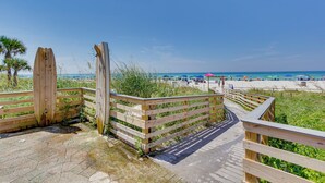 A wooden boardwalk leading to a beach with a clear view of the ocean and beach umbrellas. - Nautical Edgewater Resort Condo - Walk to Beaches! (Panama City Beach)