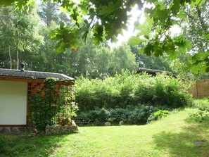A traditional Japanese-style house with a tiled roof, surrounded by lush greenery and a well-maintained garden.