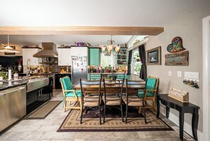 A kitchen with a dining area, wooden ceiling beams, and a chandelier. - 5 bedroom, 3 bath house on Main St. across the street from The Riggins City Park (Riggins)