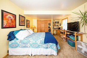 A bedroom with a bed, a desk, a television, and a fan. - 5 bedroom, 3 bath house on Main St. across the street from The Riggins City Park (Riggins)