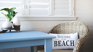 Relax in a charming corner with a wicker chair and a welcoming pillow.