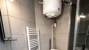 Een moderne badkamer met toilet, wastafel en douche.