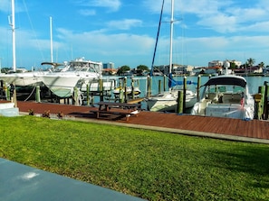 Enjoy waterfront views from the marina's wooden deck, where you can relax at a picnic table amidst lush green surroundings.